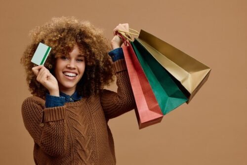 photo-studio-femme-heureuse-carte-credit-sacs-achat-colores-regardant-camera_1326977-5913